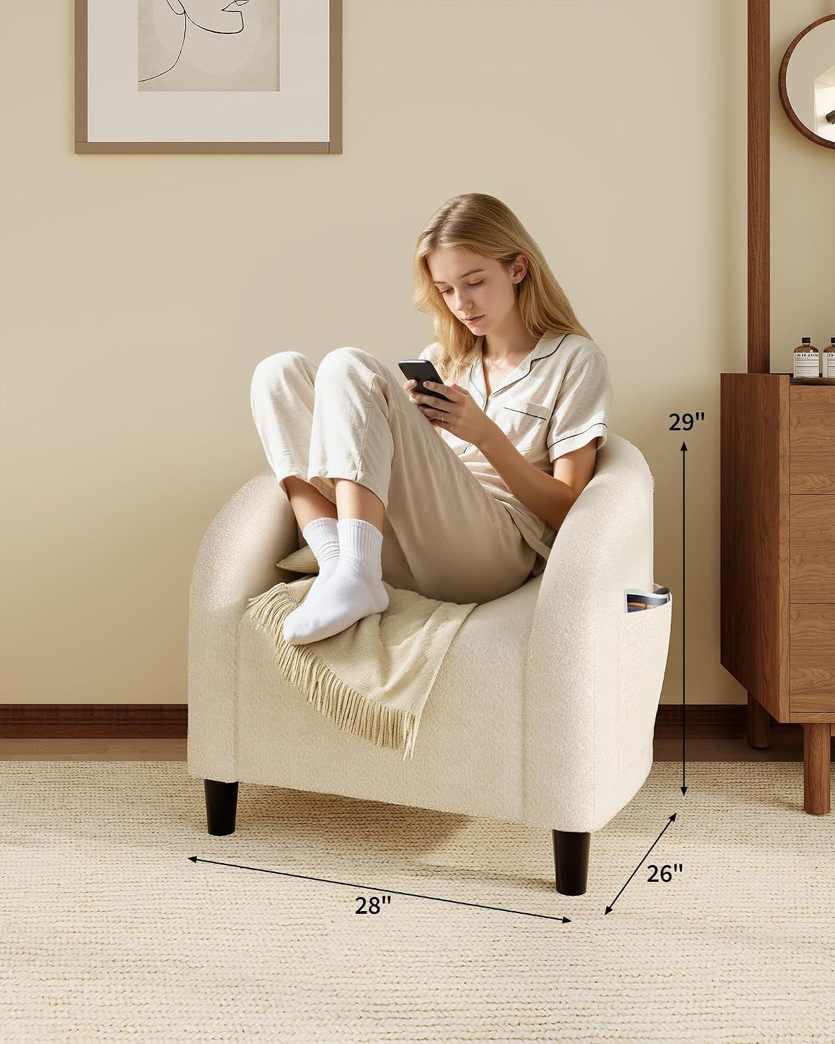 Woman sitting curled up in a beige barrel chair with arrows indicating chair dimensions on the floor and wall.