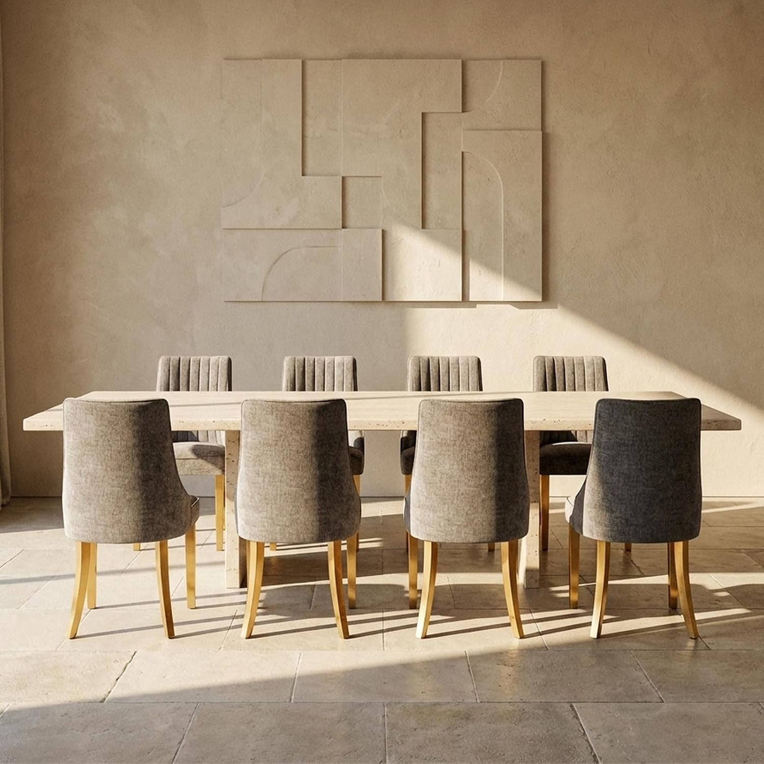 Eight grey-beige upholstered dining chairs arranged around a long stone dining table in a sunlit room.