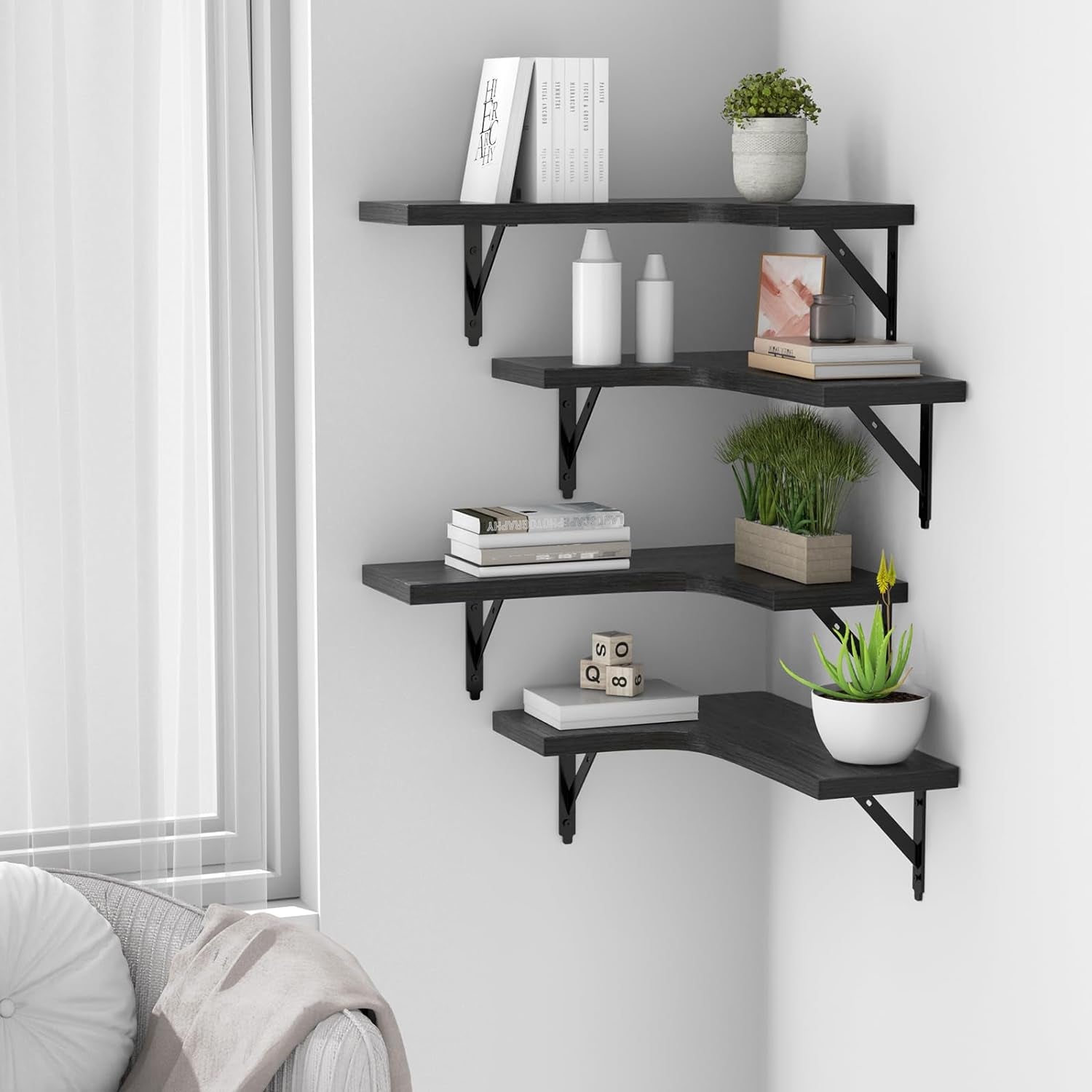 Corner installation of four black floating shelves styled with books and plants