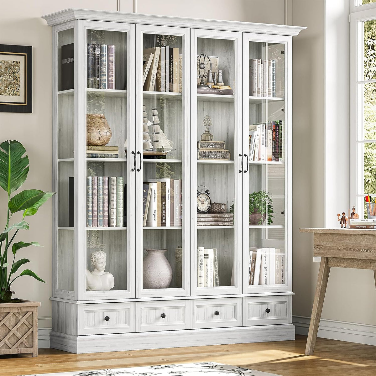 Tall four-door glass storage cabinet in light grey finish, full front view with decorative items inside