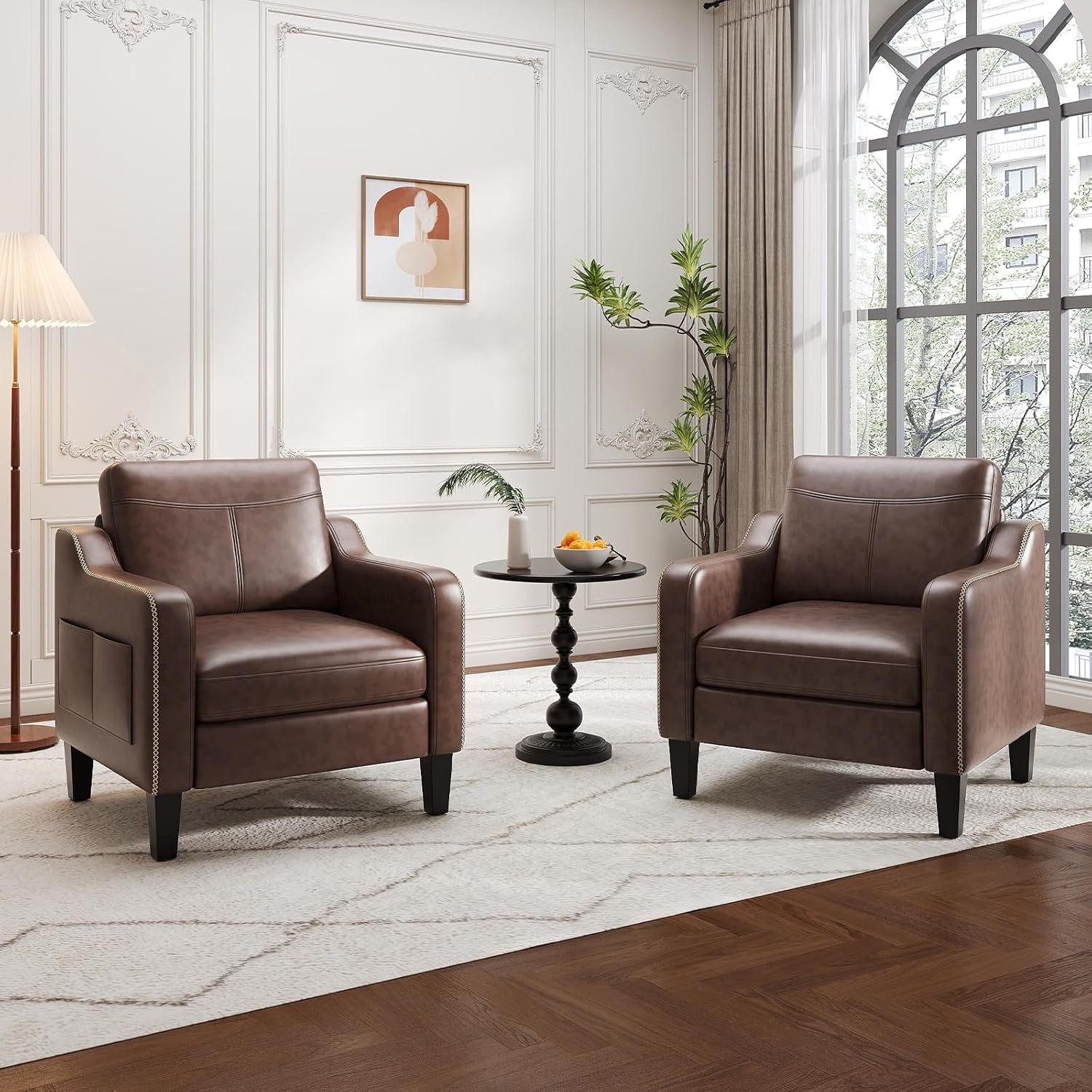 Two brown PU leather armchairs flanking a round side table in a bright living room.