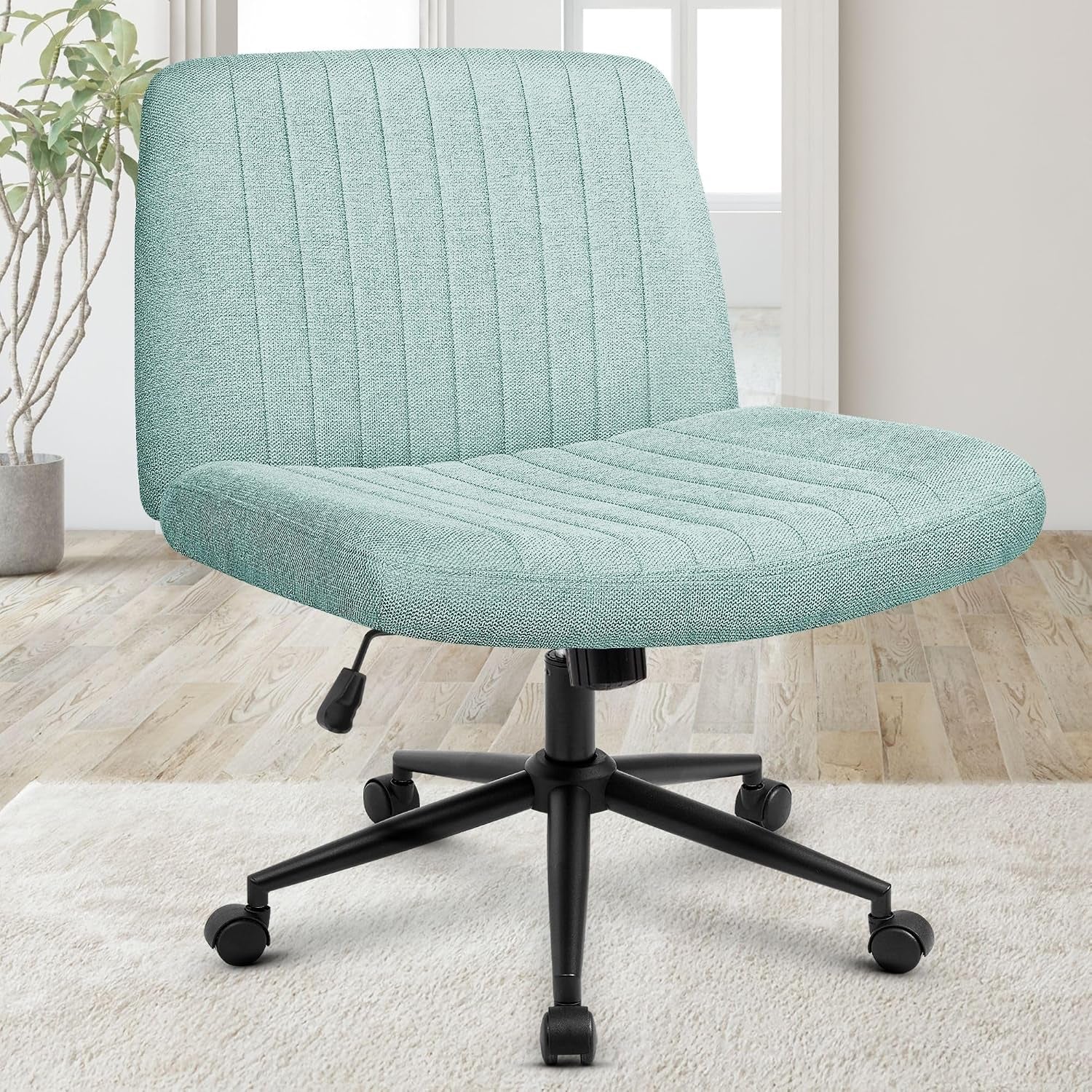 Light aqua fabric swivel chair with ribbed back and five caster wheels on a light rug in a bright room.