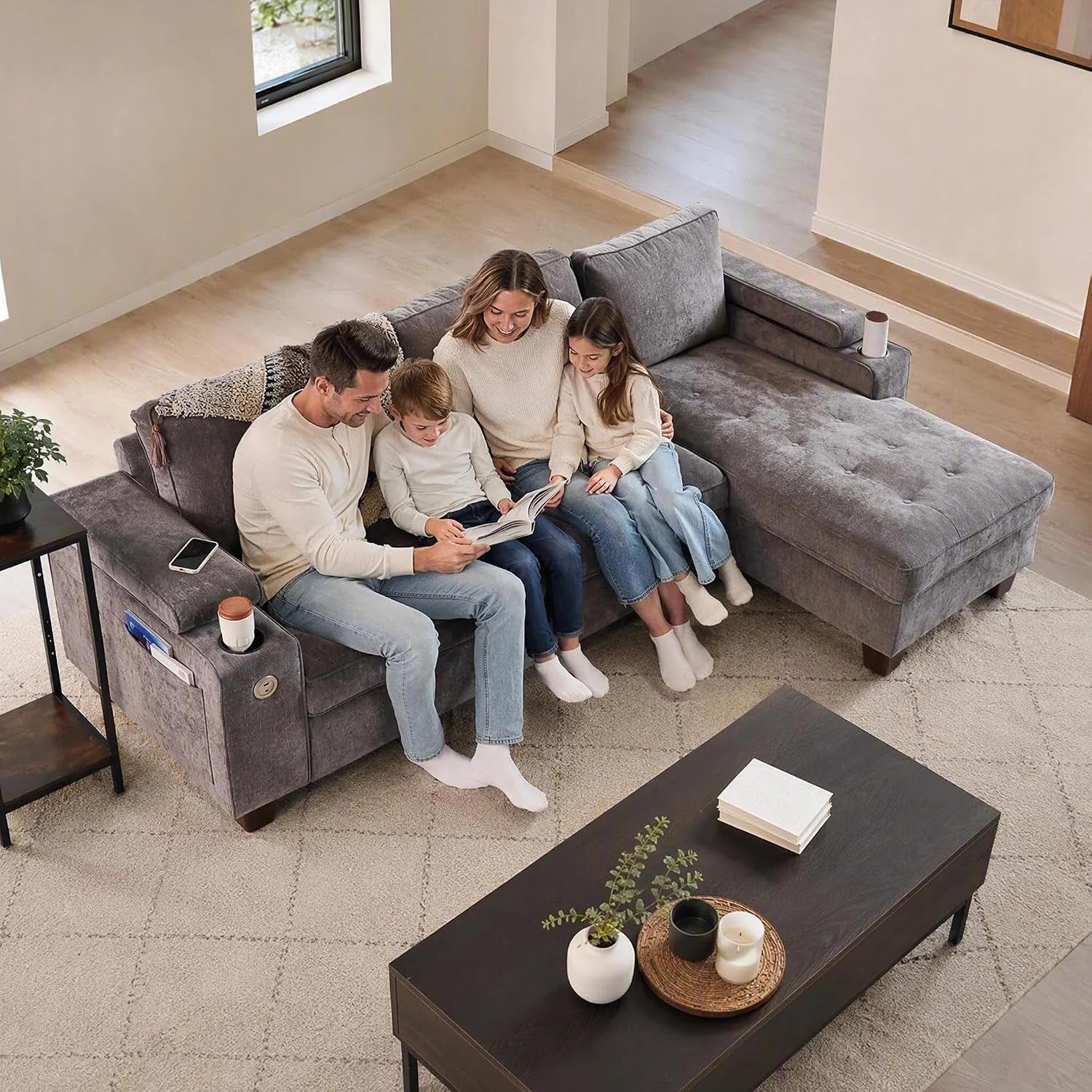 Overhead view of a gray sectional sofa with a family of four sitting together on the cushions