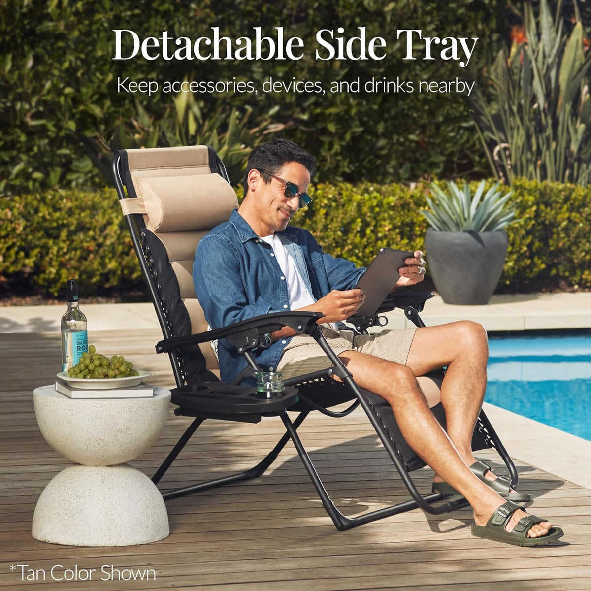 Person reclining in the padded chair by a pool with a side tray holding a drink and snacks nearby