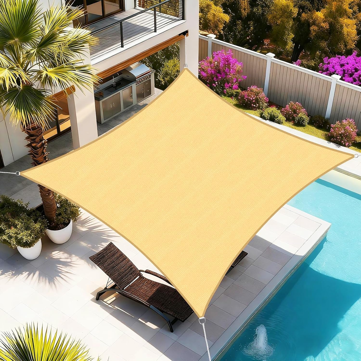 Aerial view of sand-colored rectangular shade sail with curved edges installed above a poolside patio