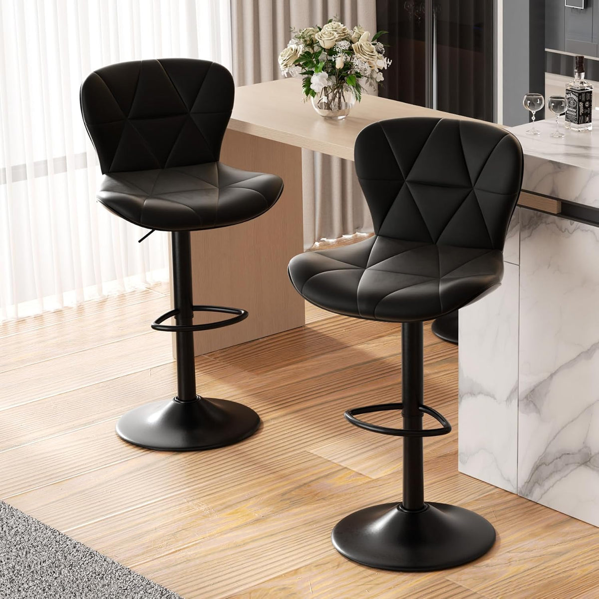 Two black faux leather adjustable bar stools positioned at a kitchen counter with wood flooring and a marble island