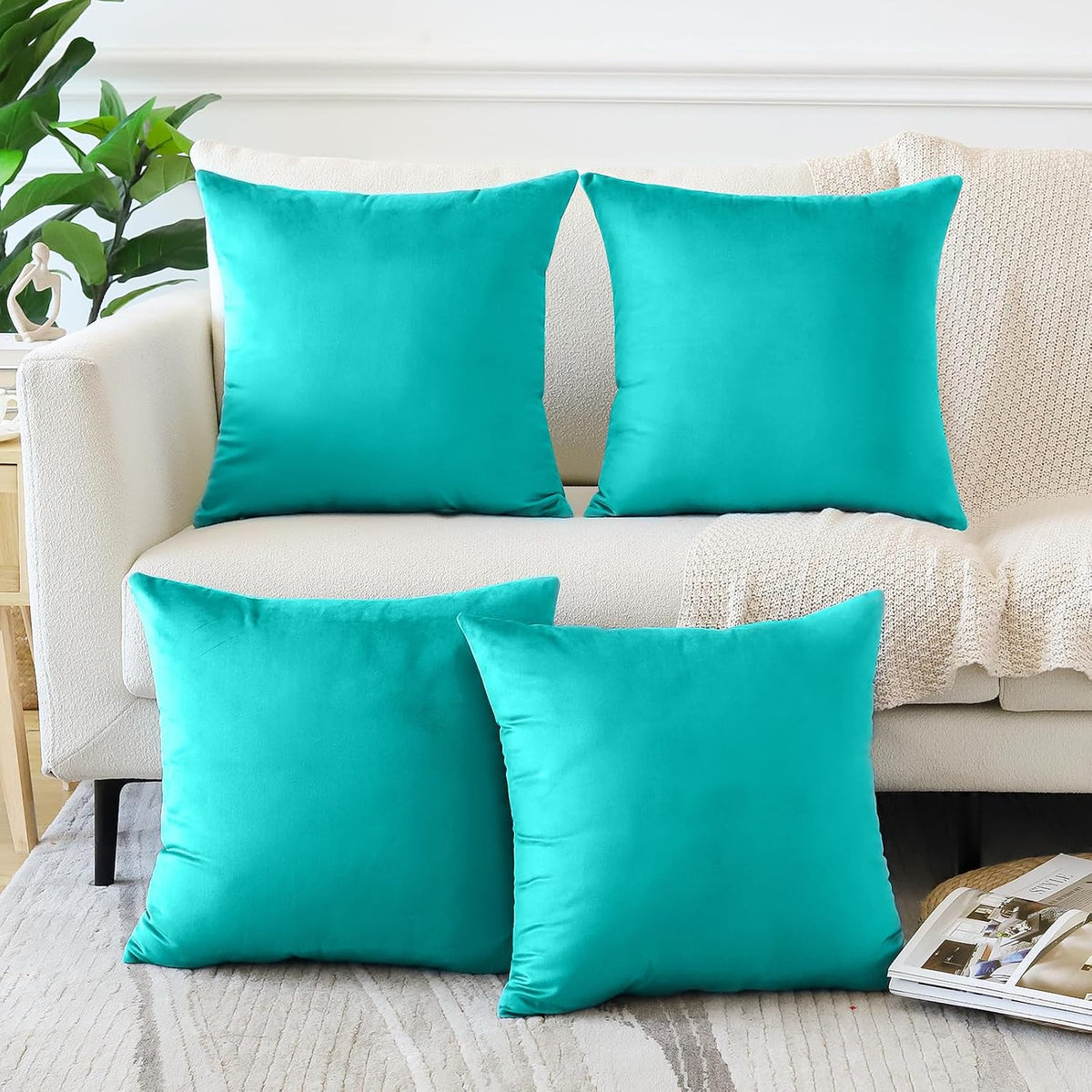 Four square teal throw pillow covers arranged on a light sofa and rug