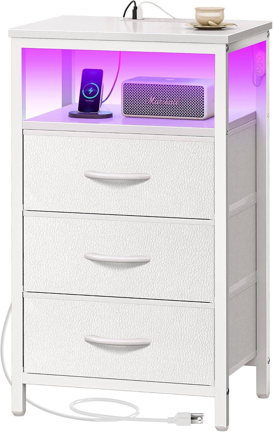 Taller white nightstand with three textured drawers, purple-lit upper shelf holding a phone charger and speaker.