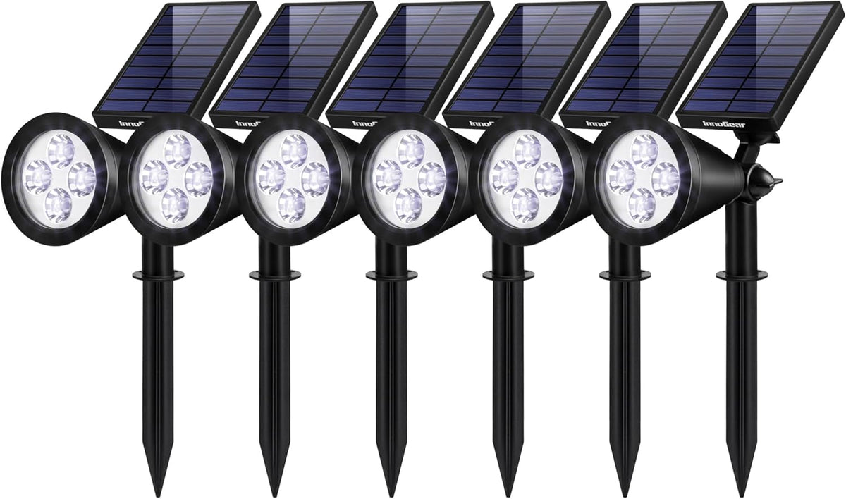 Six black solar spotlight stakes arranged in a row, each with a round head and a tilted rectangular solar panel.