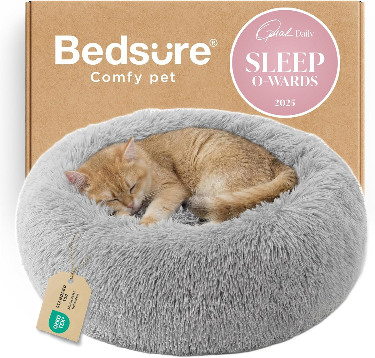 Light gray fluffy donut pet bed with a curled sleeping orange kitten shown against a cardboard backdrop