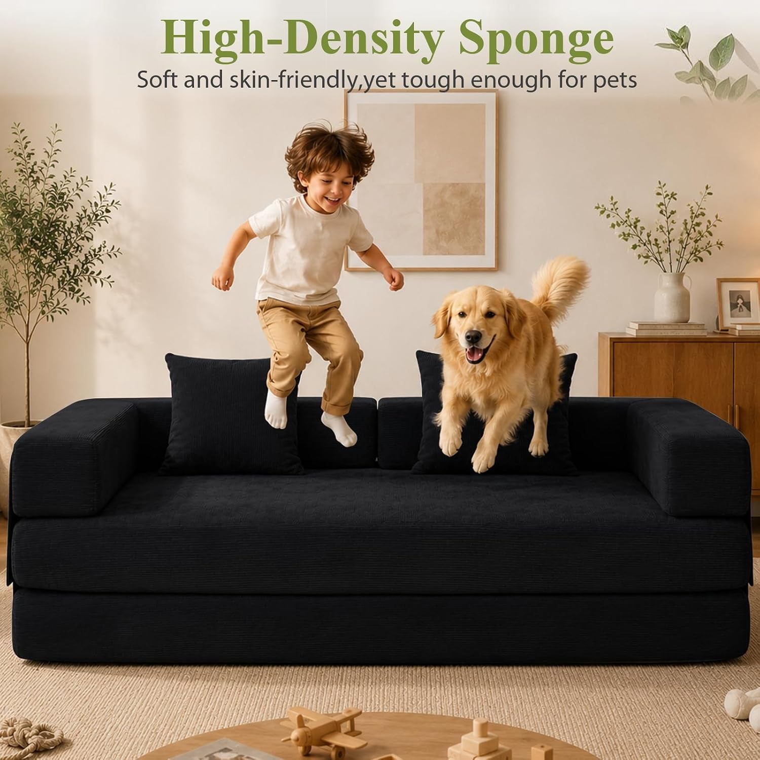 Front view of a black corduroy loveseat with a child and a golden retriever jumping on it in a living room.