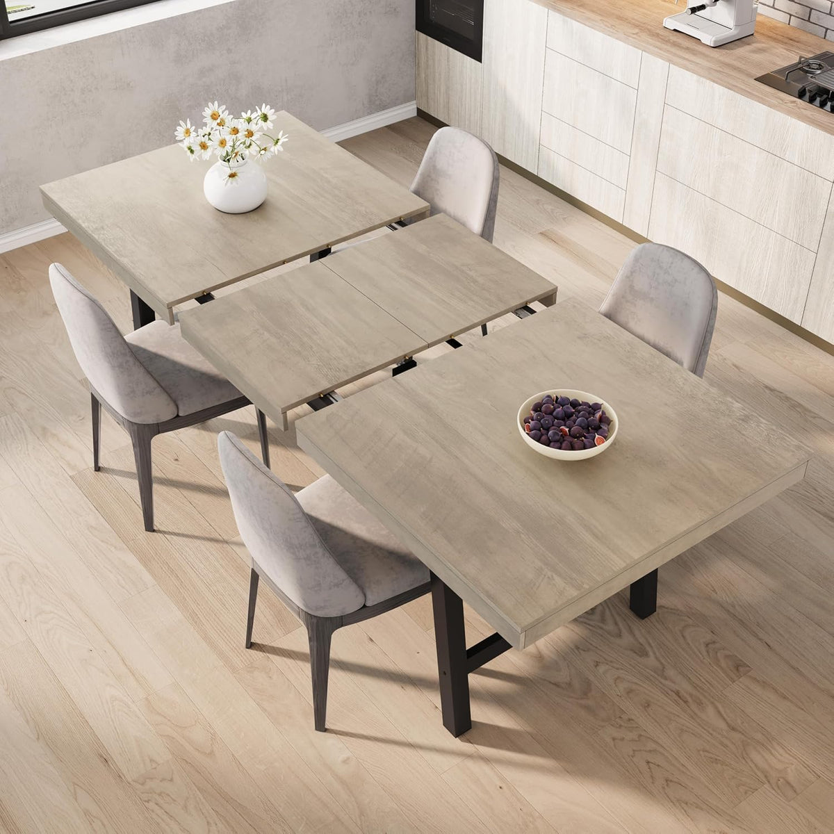 Light woodgrain laminate extendable dining table partially extended, top view with black metal legs in a kitchen