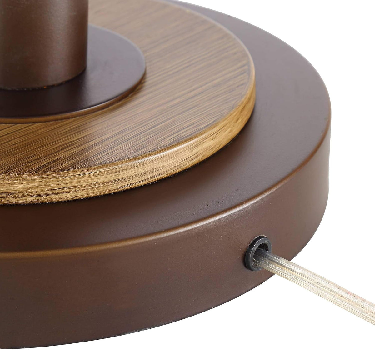Detail of clear silver power cord exiting the bronze base and wood-grain accent on the base