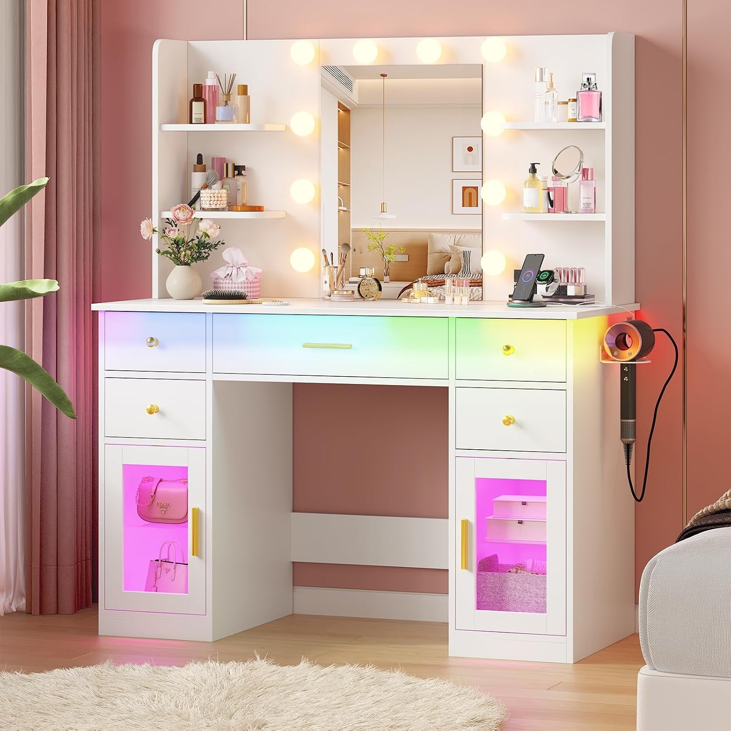 White vanity in a pink room with round vanity bulbs, RGB under-drawer lighting and a hairdryer mounted on the side