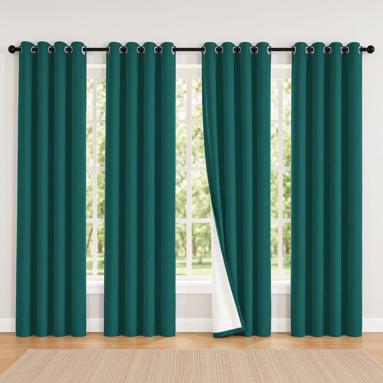 Four teal curtain panels on a rod with one panel folded back to show white thermal backing