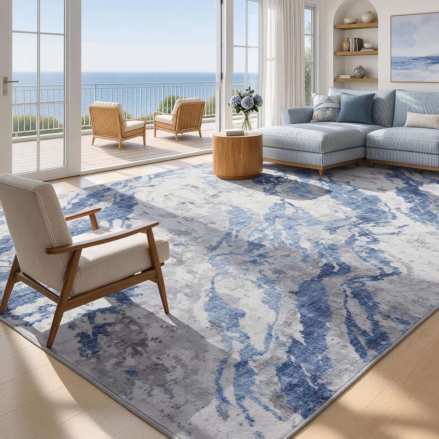 Large rectangular blue-and-white rug covering most of a sunlit living room floor with a striped sectional and ocean view