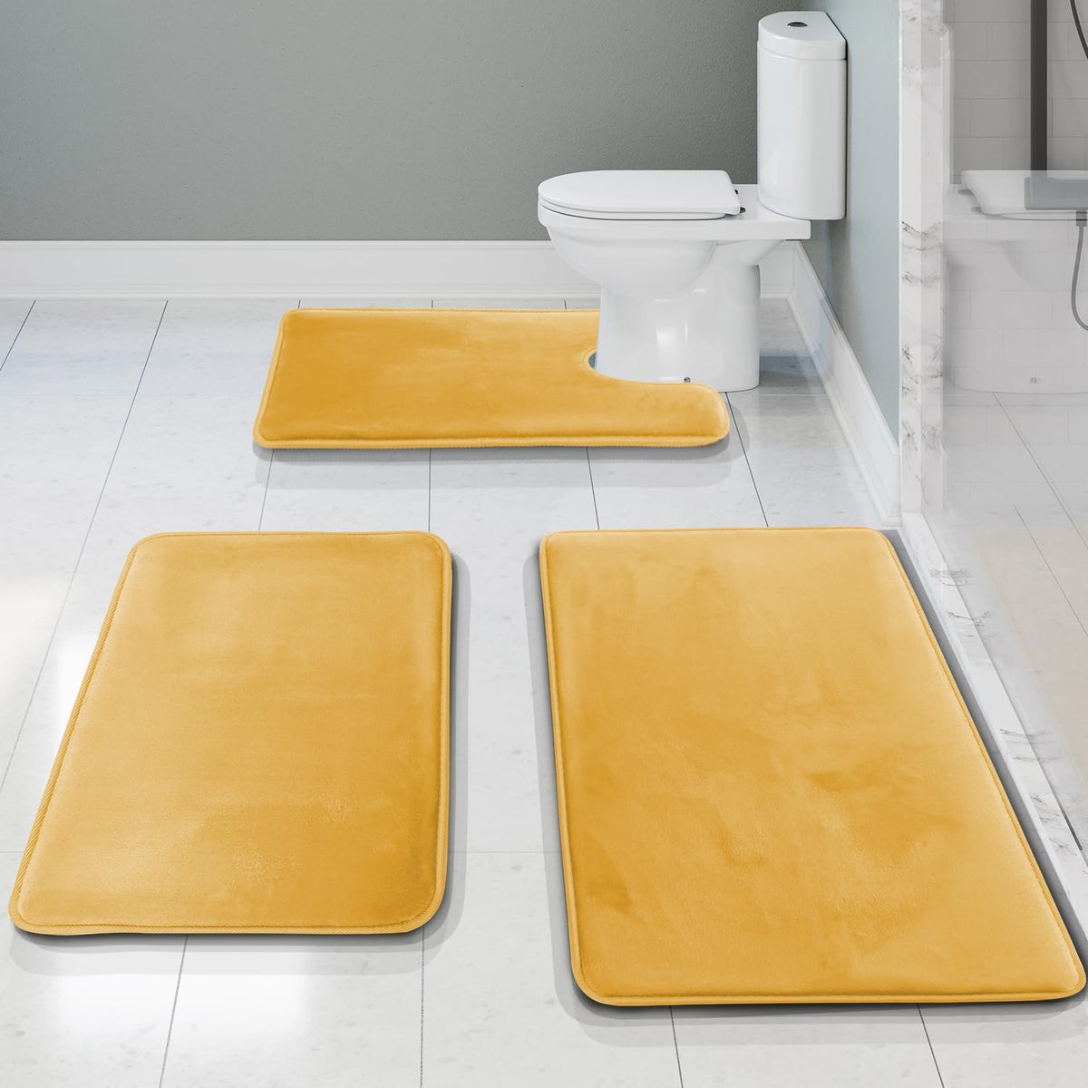 Low-angle bathroom view showing three mustard-yellow memory foam mats, U-contour placed at the toilet.