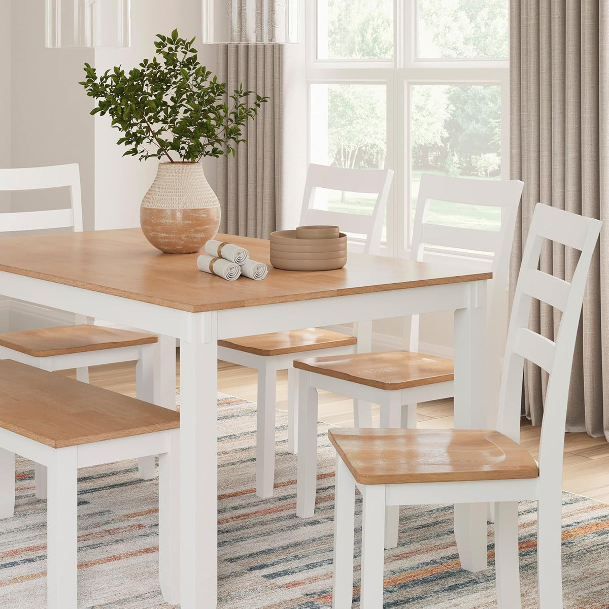 Rectangular two-tone table and matching bench and chairs in a bright dining room, close-up view of tabletop and seating