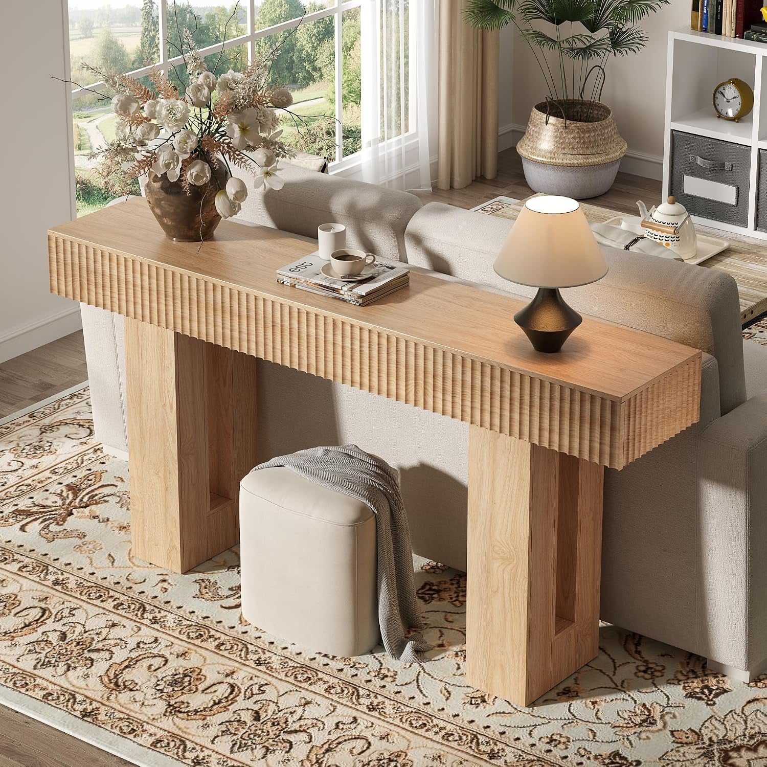 Natural oak console table placed behind a sofa showing the long tabletop and open base storage