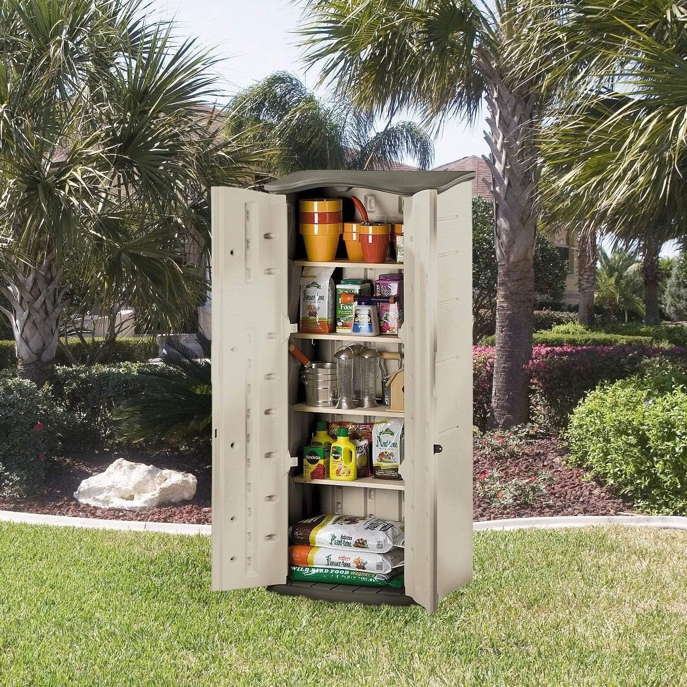 Open beige resin shed showing interior shelving stocked with garden supplies on a lawn