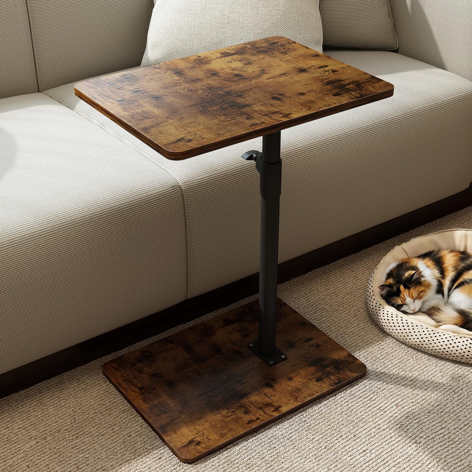 Warm rustic brown wood C-shaped side table beside a sofa with a calico cat sleeping nearby.