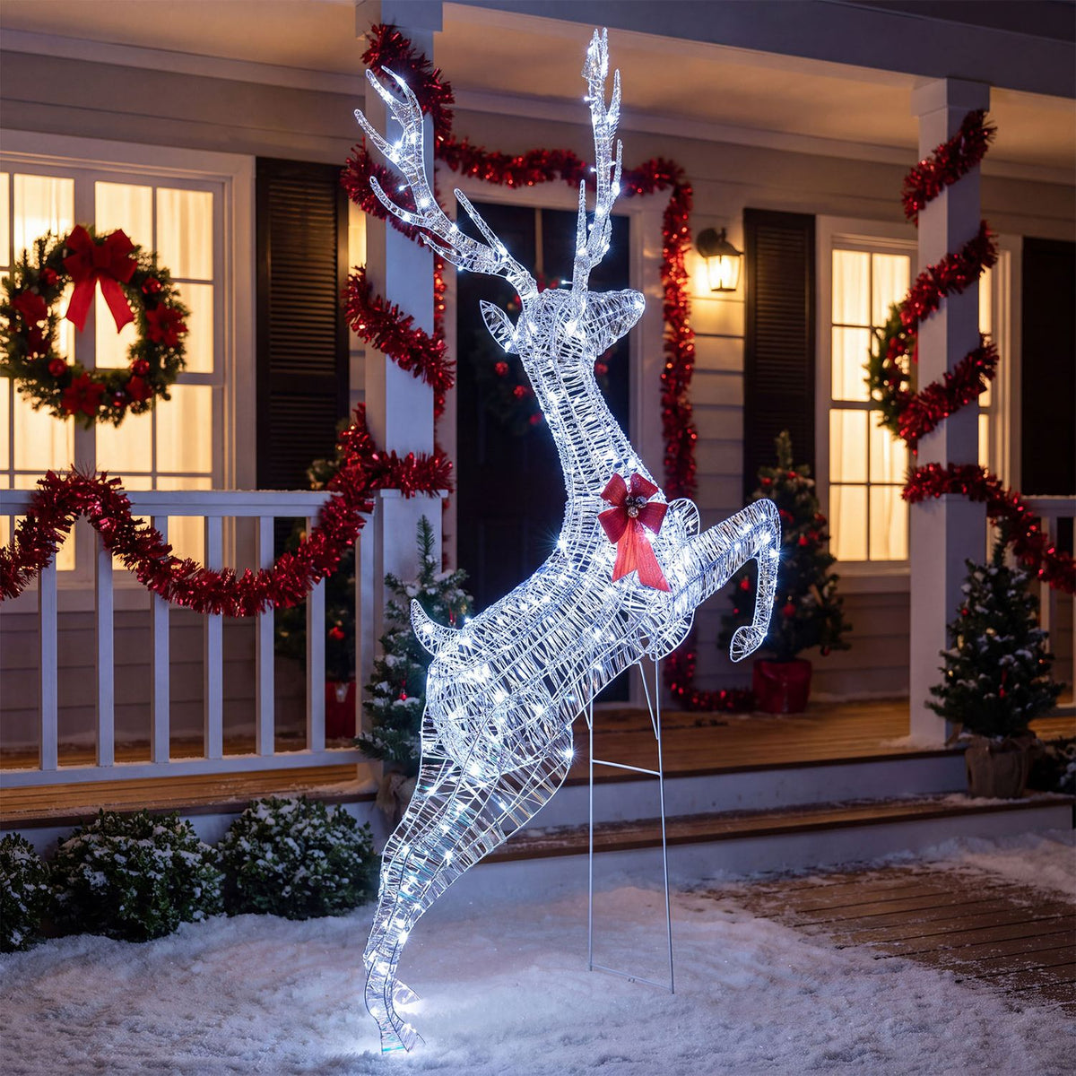 Glowing wireframe reindeer with a red bow posed mid-leap on a snow-covered porch decorated for Christmas.