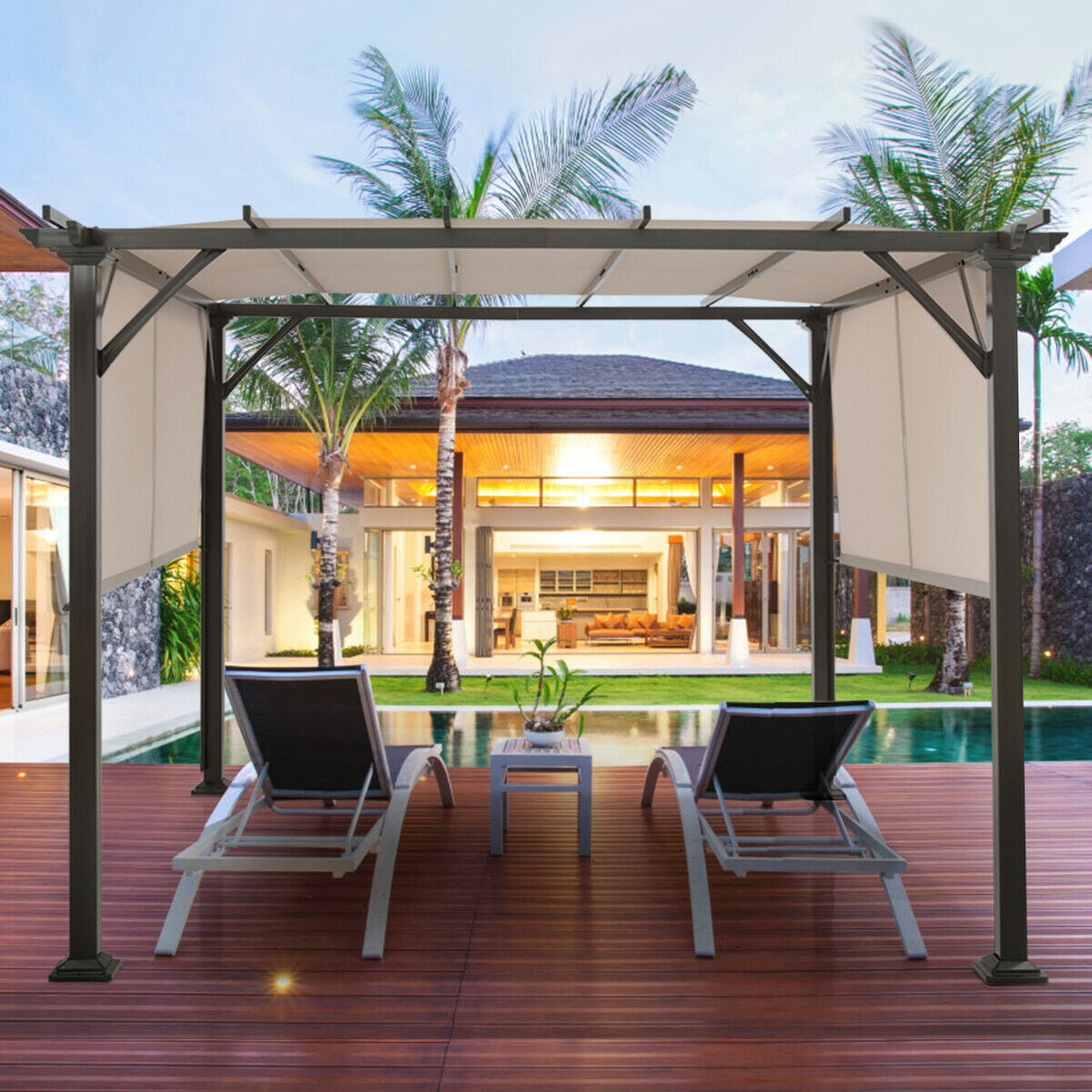 Two lounge chairs sit beneath the shelter on a deck beside a swimming pool.