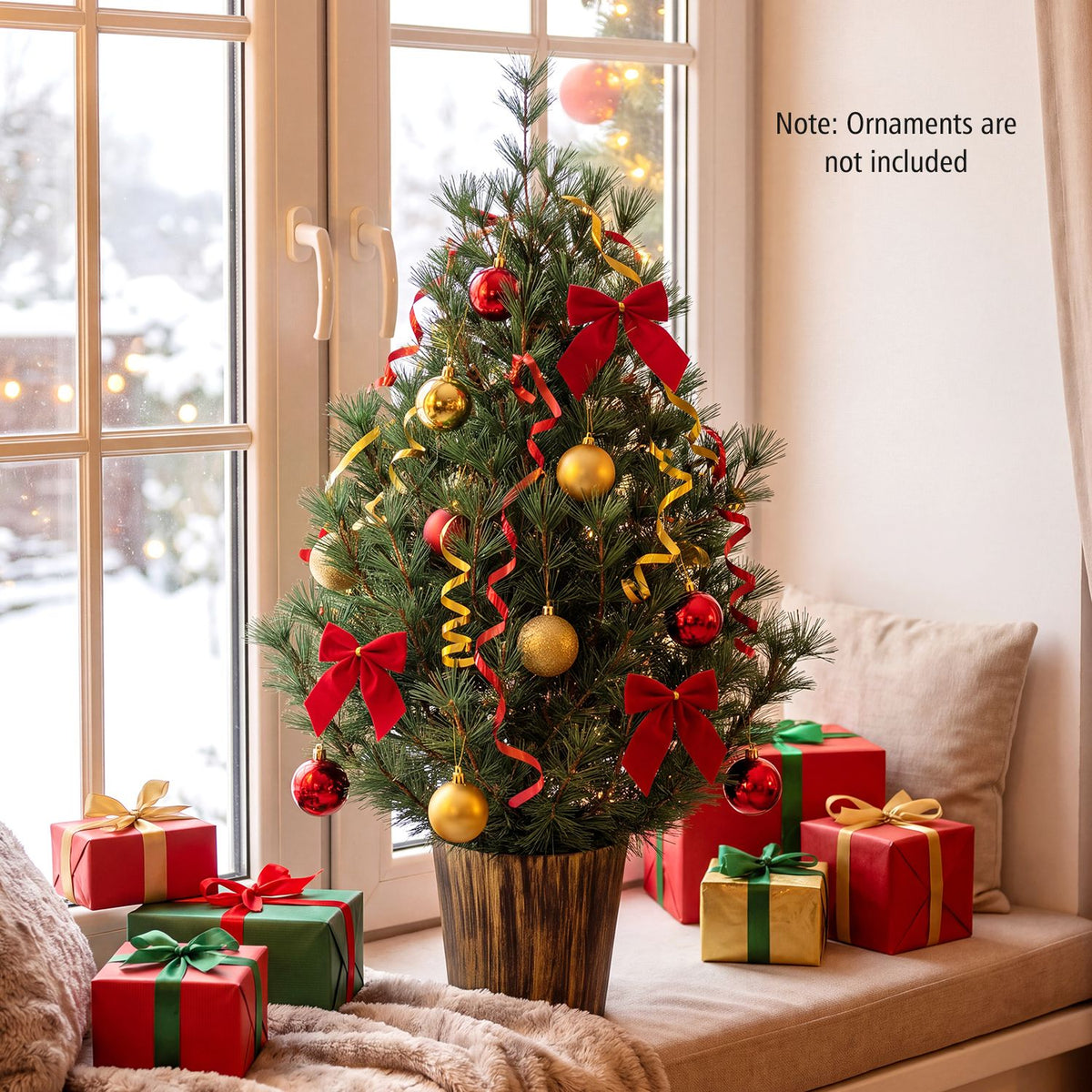 Decorated potted Christmas tree by a window, surrounded by ornaments and wrapped gifts
