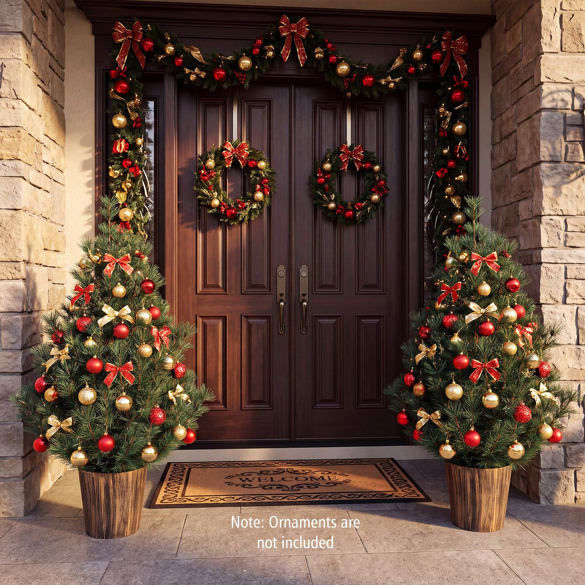 Two decorated potted Christmas trees flanking a dark front door
