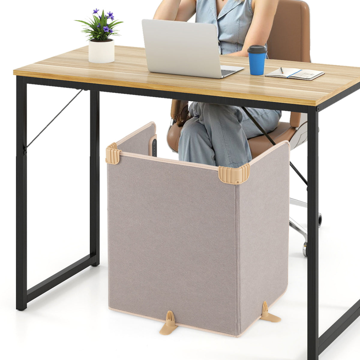 A person sits at a desk with the folded heater arranged around their legs underneath.
