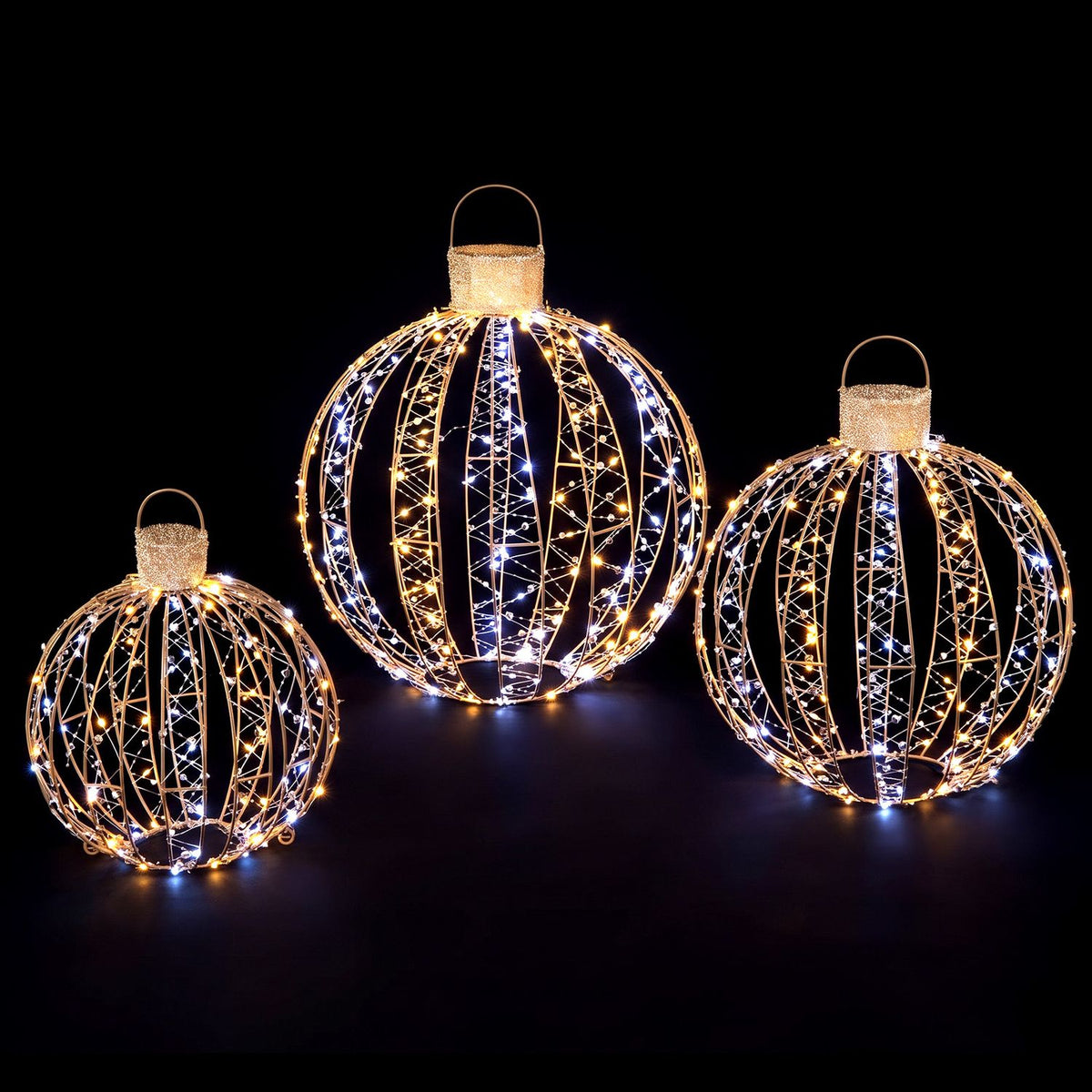 Three glowing wire-frame ornament balls are shown against a black background.