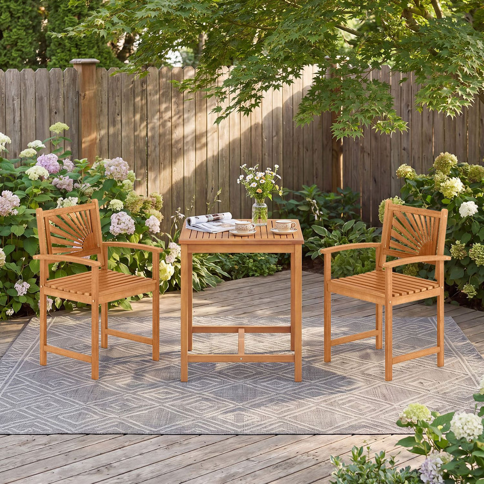 Wooden patio dining set with two slatted armchairs and a square table on a garden deck.