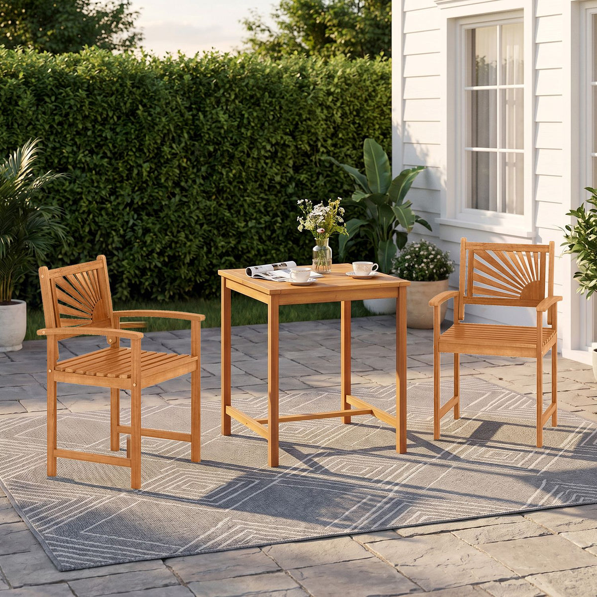 A square wooden patio table set with two slatted-back chairs on a rug beside a house.
