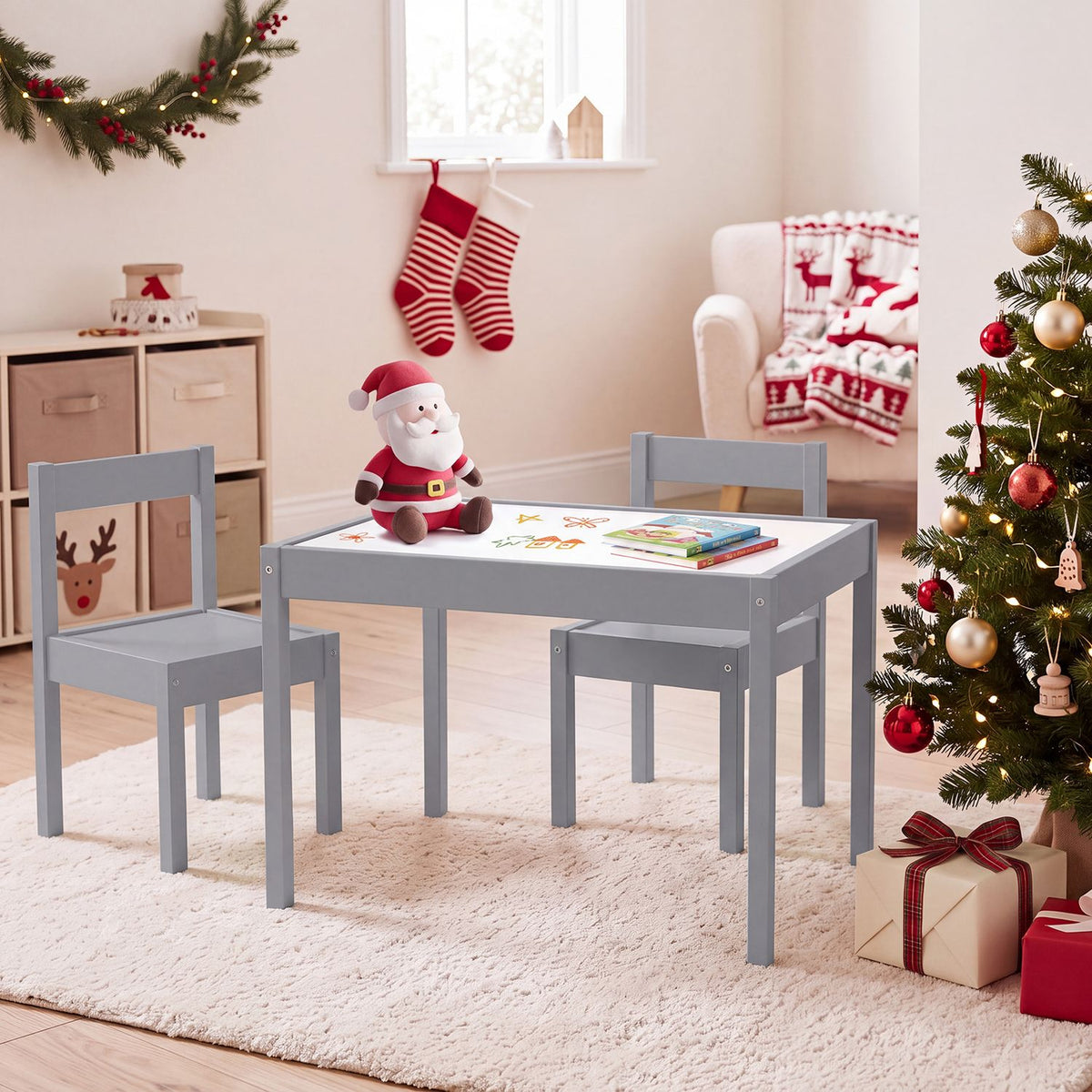 Gray activity table and two chairs arranged on a rug in a Christmas-decorated room.