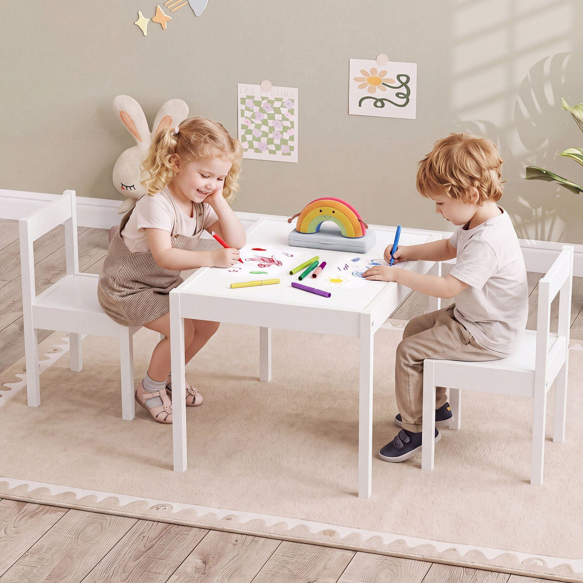 Two children draw at a white activity table with matching chairs.