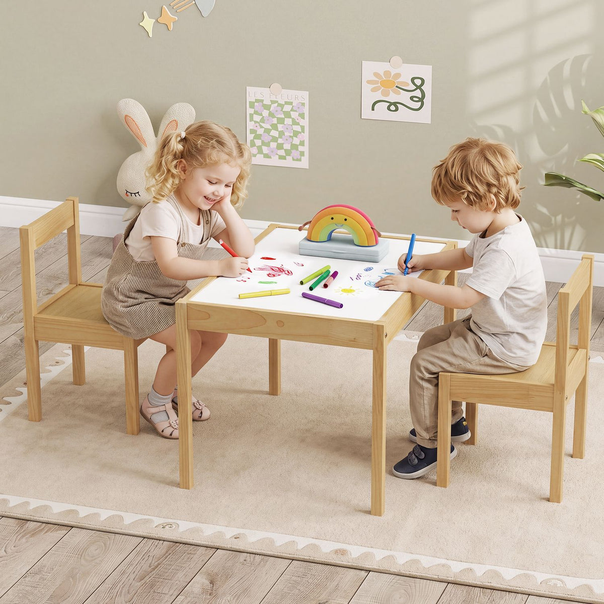 Two children draw together at a light wood table with matching chairs.