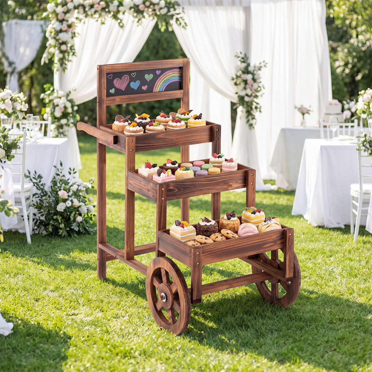 Wooden tiered cart on a lawn, holding pastries at an outdoor celebration.