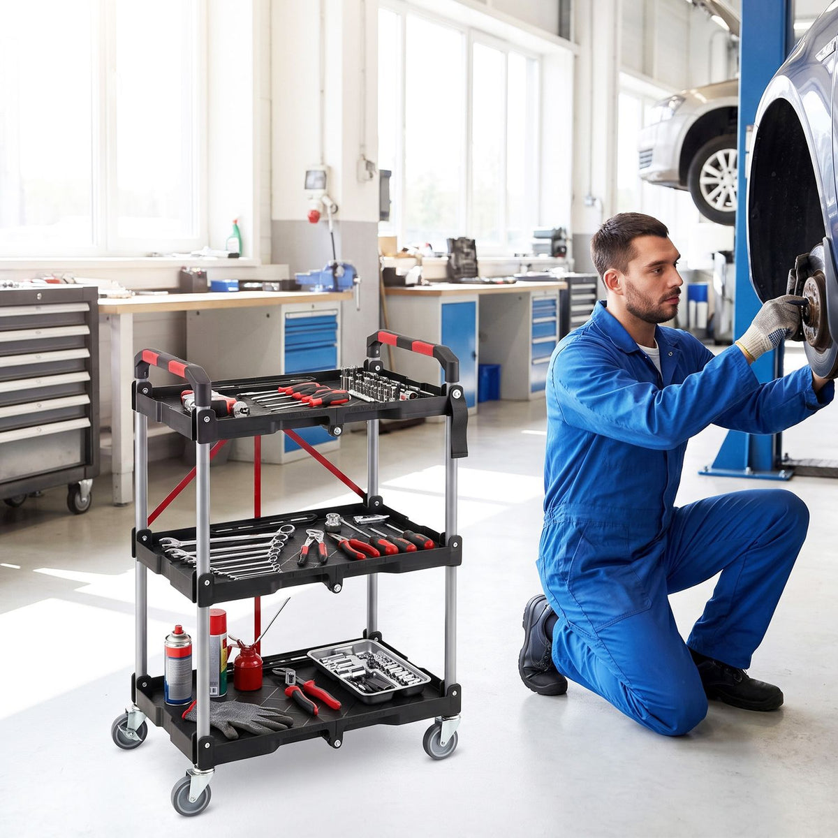 Black three-tier utility cart loaded with tools beside a mechanic in a workshop