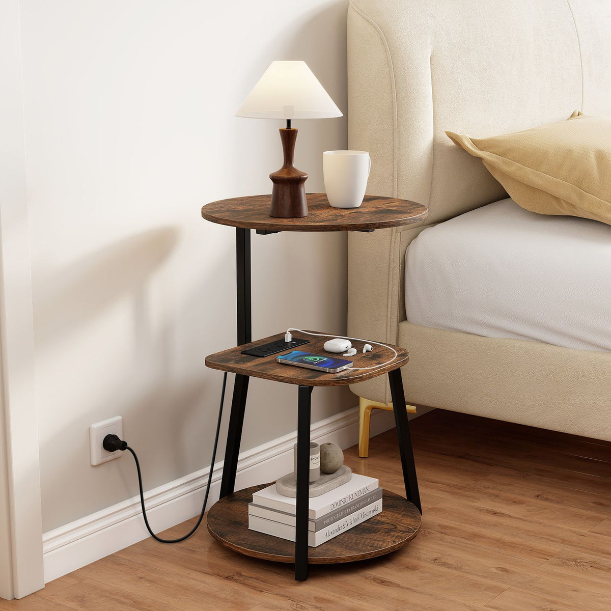 Rustic brown and black three-tier round table beside a bed