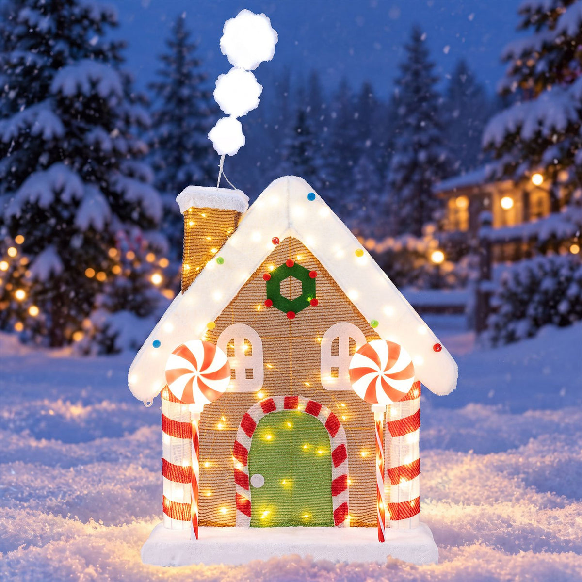 Illuminated gingerbread house decoration glowing in a snowy forest scene at night.