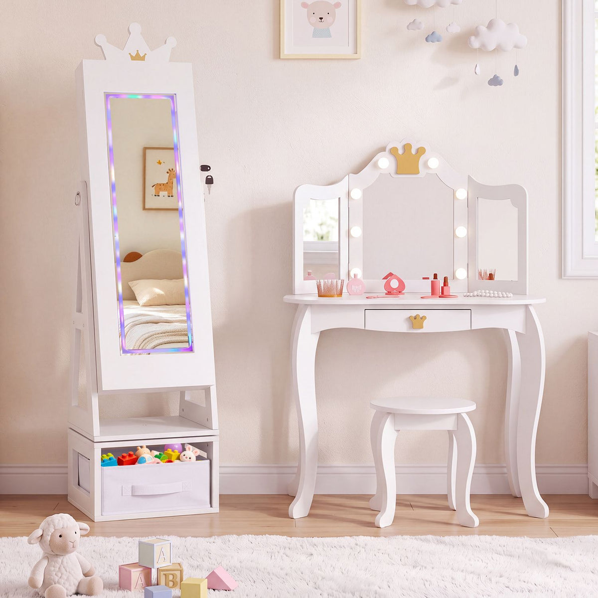 White crown-topped mirror cabinet beside a matching lighted vanity and stool in a softly decorated child’s room.