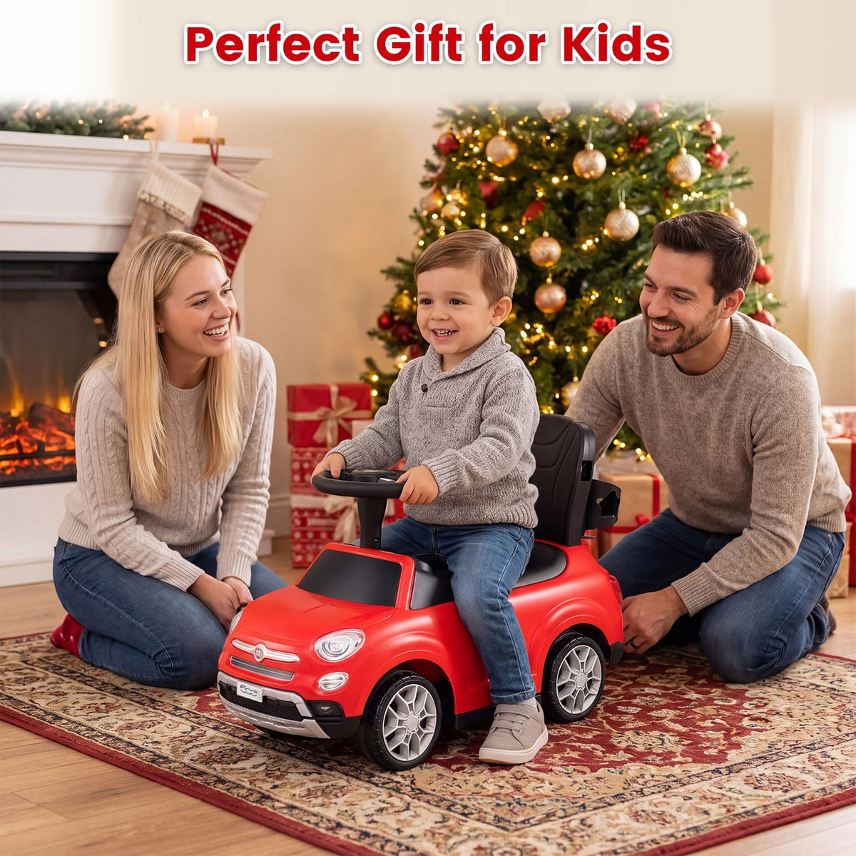 A child sits on a red ride-on car as two adults smile beside a decorated Christmas tree.