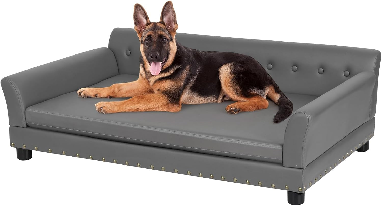 Gray leather dog sofa on white background with a German shepherd reclining on top.