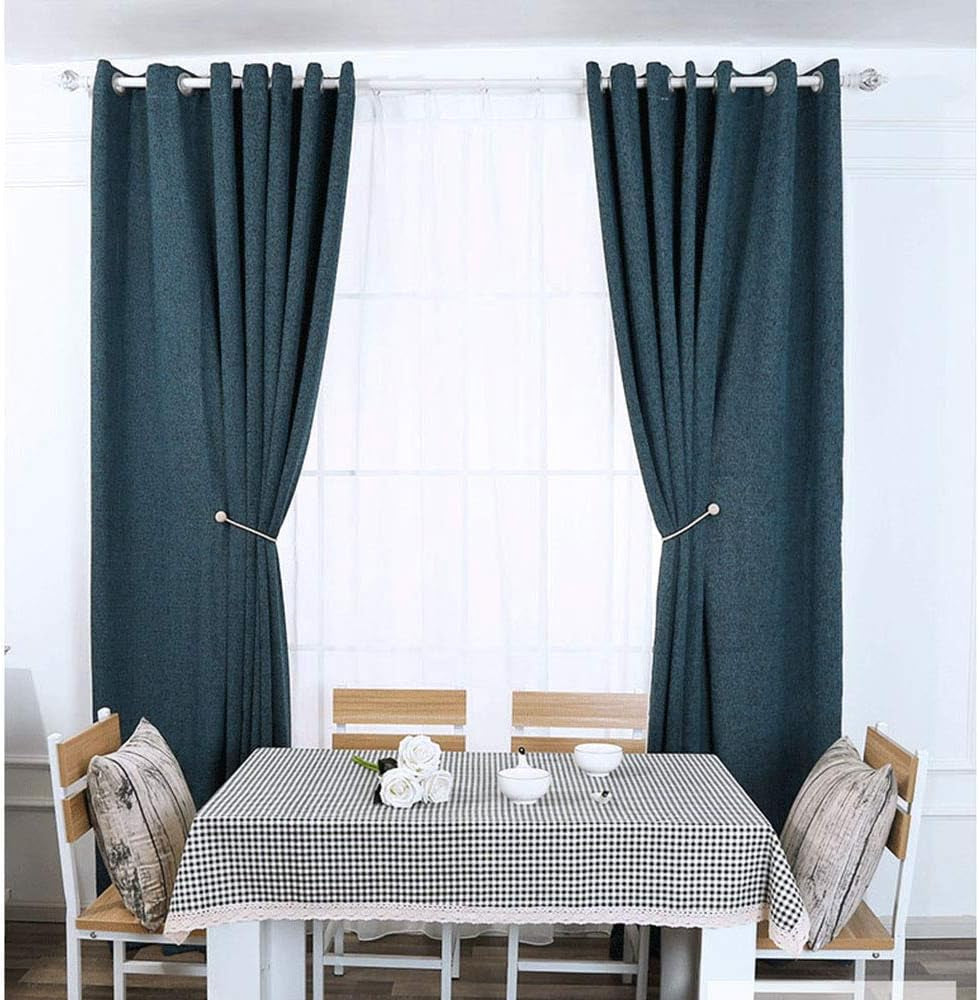 Wide view of teal curtains on a rod with white beaded magnetic tiebacks securing each panel in a living room setting.