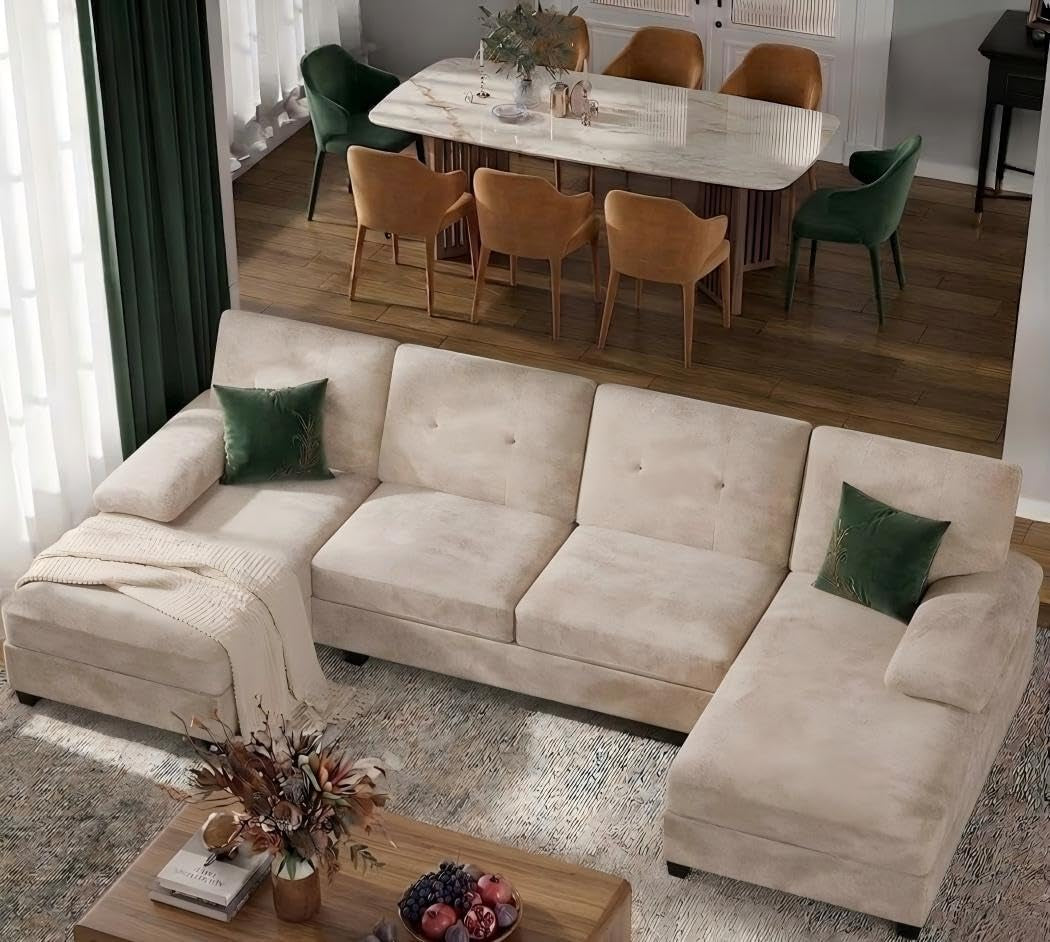 Light beige U-shaped sectional with double chaise and green throw pillows.