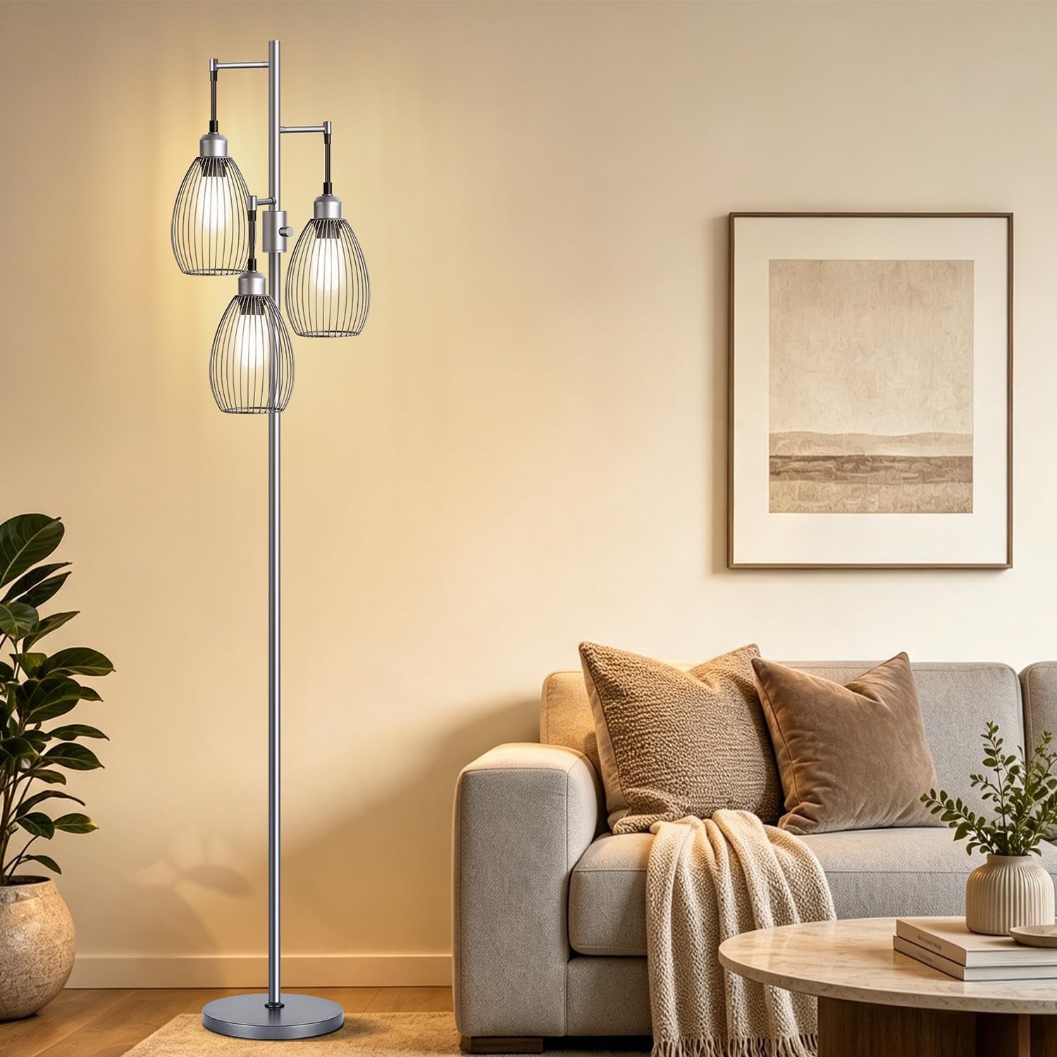 Tall floor lamp with three teardrop wire cages lit beside a beige sofa, rug, plant, and framed wall art.
