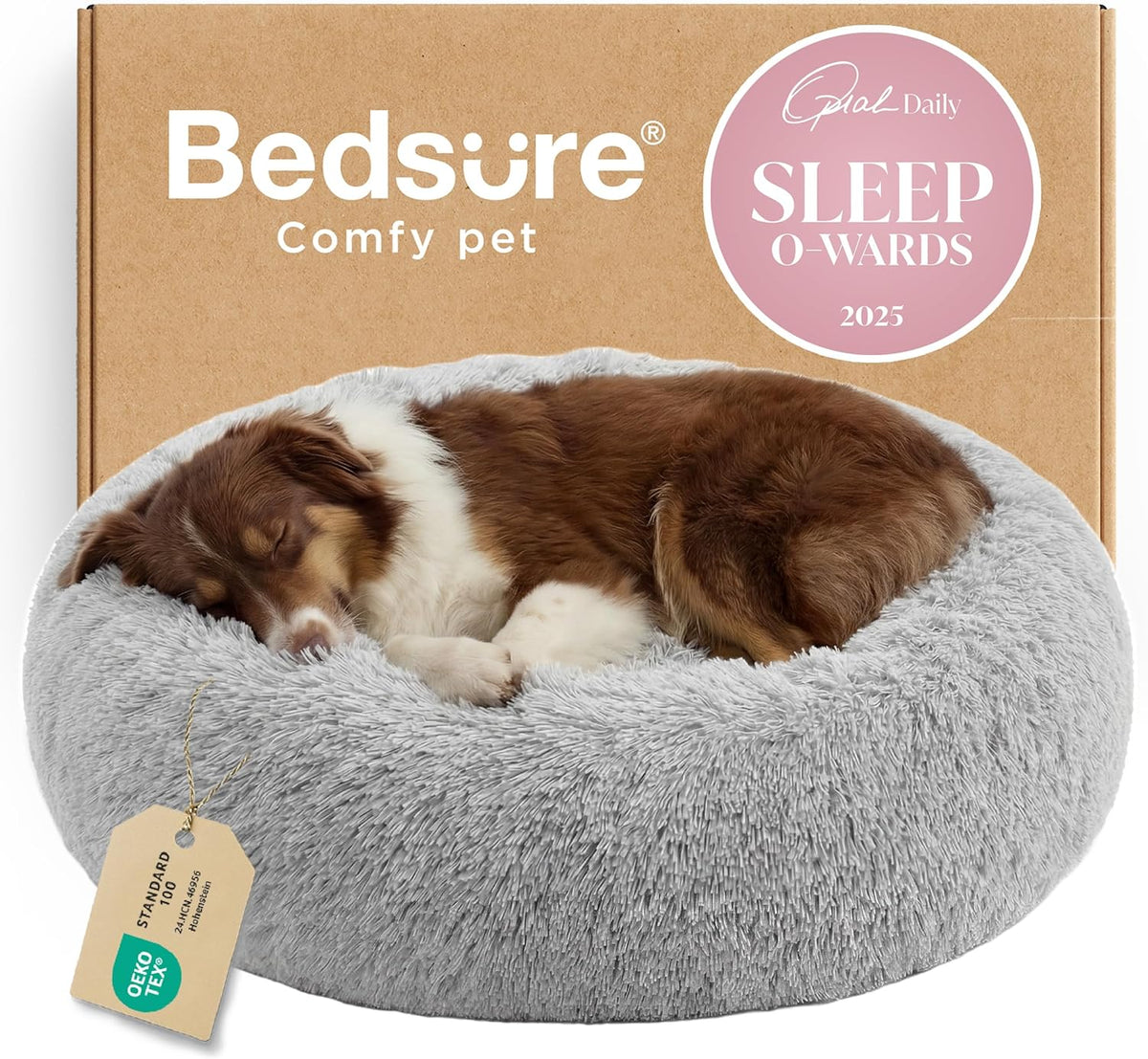Brown-and-white dog asleep in a light gray round plush donut bed shown on box backdrop