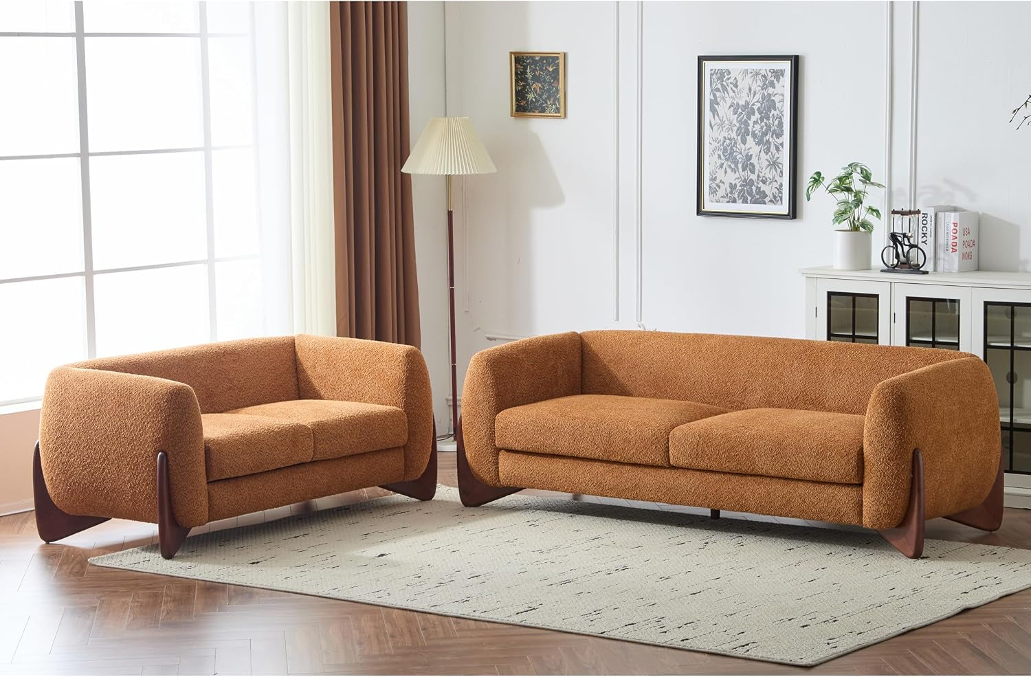 Warm-toned living room with burnt orange sofa and loveseat on a patterned rug