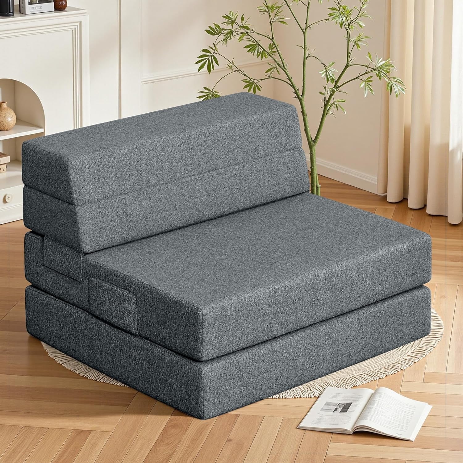 Angled close shot of dark gray tri-fold foam sofa showing backrest and seat layers in a living room setting