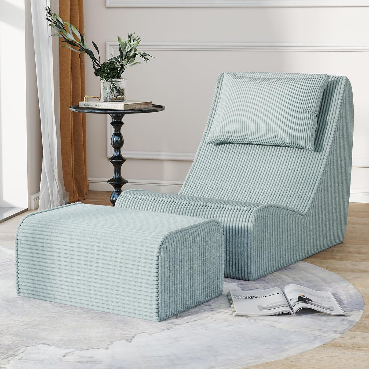 Pale blue chaise and ottoman arranged on a round rug beside a black side table and draped curtains